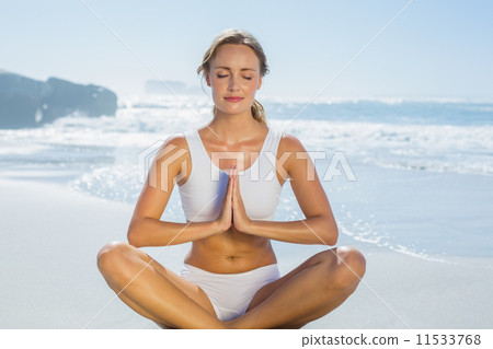 Gorgeous blonde in lotus pose by the sea Gorgeous blonde in lotus pose by the sea 11533768