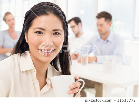 Casual businesswoman smiling at camera during meeting Casual businesswoman smiling at camera during meeting 11533772
