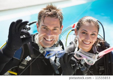 Smiling couple on scuba training in swimming pool showing ok ges Smiling couple on scuba training in swimming pool showing ok ges 11533853