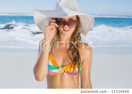 Beautiful girl in bikini and straw hat smiling at camera on beac 11534049
