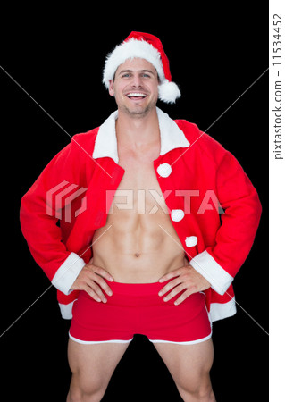 Smiling muscular man posing in sexy santa outfit Smiling muscular man posing in sexy santa outfit 11534452