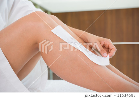 Woman waxing her legs herself Woman waxing her legs herself 11534595