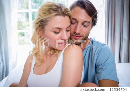 Cute young couple relaxing on bed together Cute young couple relaxing on bed together 11534704