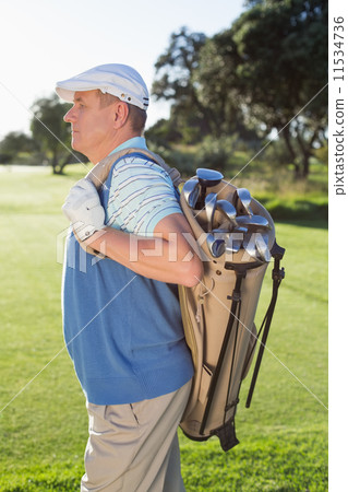 Golfer standing holding his golf bag 11534736