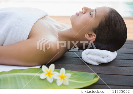Peaceful brunette lying with eyes closed on a towel Peaceful brunette lying with eyes closed on a towel 11535092