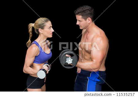 Crossfit couple posing with dumbbells Crossfit couple posing with dumbbells 11535257