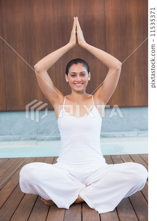 Peaceful happy woman in white sitting in lotus pose 11535371