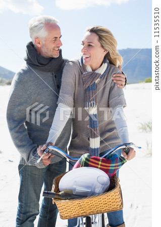 Carefree couple going on a bike ride and picnic on the beach Carefree couple going on a bike ride and picnic on the beach 11535510
