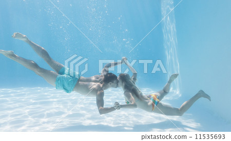 Cute couple holding hands underwater in the swimming pool 11535693