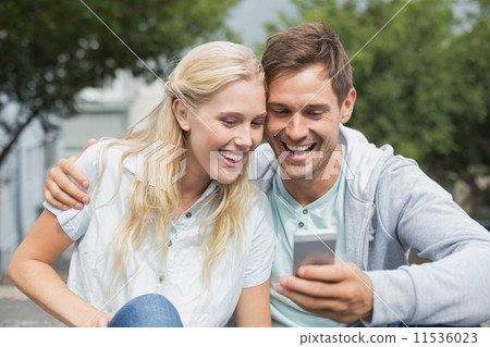 Hip young couple looking at smartphone 11536023
