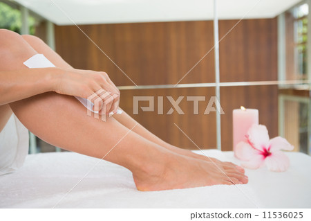 Woman waxing her legs herself Woman waxing her legs herself 11536025