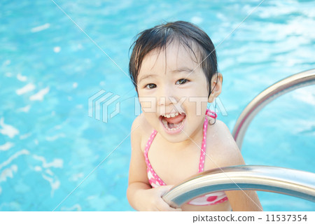 A girl with a smile playing in the pool A girl with a smile playing in the pool 11537354