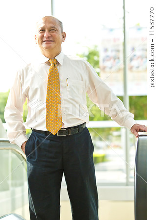 Senior businessman going up the escalator Senior businessman going up the escalator 11537770