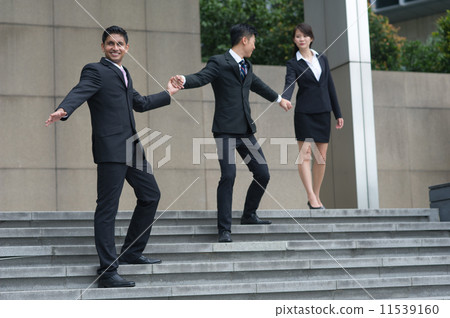 A teamof mult-ethnic and talented teammates helping each other by hand to walk down the stair A teamof mult-ethnic and talented teammates helping each other by hand to walk down the stair 11539160