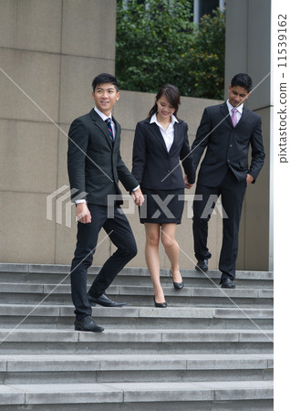 A team of three young, multi-ethnicity and happy colleagues walking down the stairs holding hands A team of three young, multi-ethnicity and happy colleagues walking down the stairs holding hands 11539162