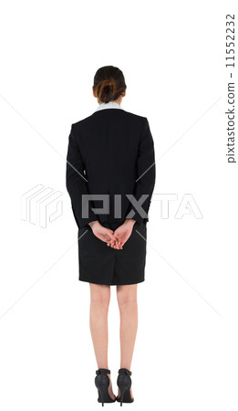 Businesswoman in suit standing with hands behind back 11552232