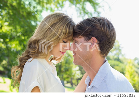 Cute couple facing each other in the park Cute couple facing each other in the park 11553832