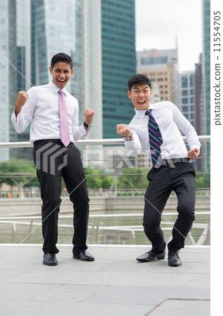 Two overjoyed co-workers punch their fists in the air to celebrate success 11554705