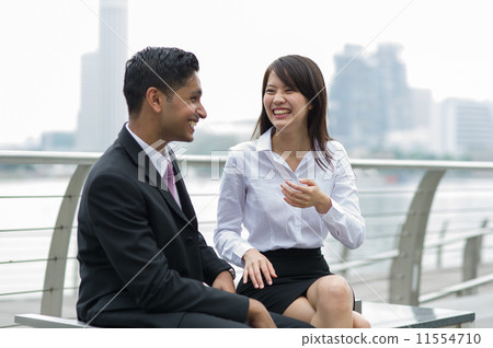 Two young colleagues sharing some jokes during lunch / break time Two young colleagues sharing some jokes during lunch / break time 11554710