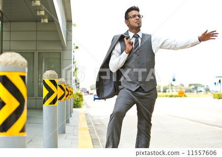 Young businessman hailing for a taxi on the street Young businessman hailing for a taxi on the street 11557606