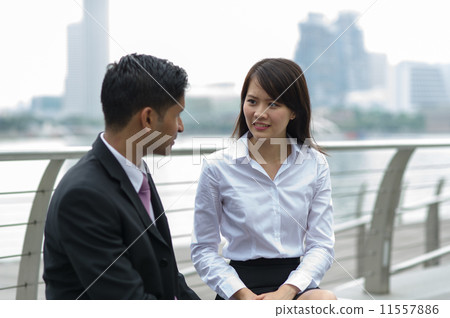 A young Chinese lady is giving counsel to her male Indian client A young Chinese lady is giving counsel to her male Indian client 11557886