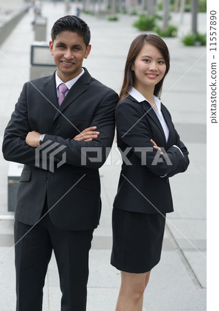 A friendly Chinese lady and her male Indian business partner posing with their arms folded 11557890
