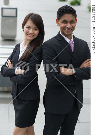 A friendly Chinese lady and her male Indian business partner posing with their arms folded A friendly Chinese lady and her male Indian business partner posing with their arms folded 11557891