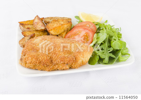 Wiener Schnitzel - Breaded fried veal, potato wedges and salad. Wiener Schnitzel - Breaded fried veal, potato wedges and salad. 11564050