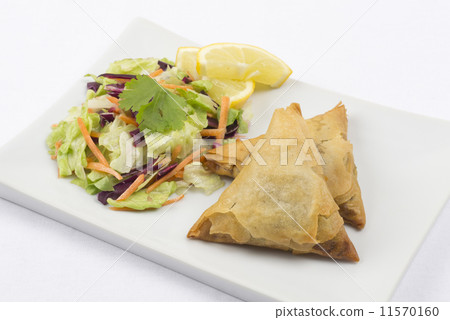 Samosas served with salad and lemon slices  11570160