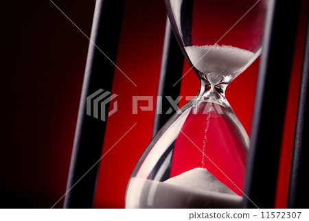Egg timer or hourglass on a red background Egg timer or hourglass on a red background 11572307
