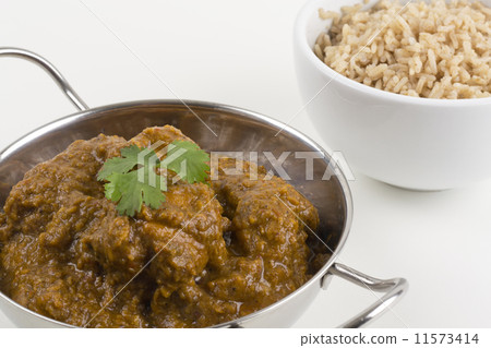 Goan Chicken Chacuti served & pilau rice on a white background Goan Chicken Chacuti served & pilau rice on a white background 11573414