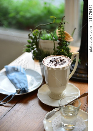 Cup of coffee with simple syrup on wooden table in a petite cafe  11576482