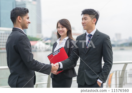 A successful Chinese businessman with his female assistant hand shake with his Indian partner A successful Chinese businessman with his female assistant hand shake with his Indian partner 11576560