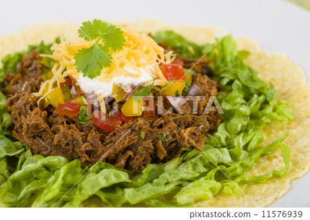 Mexican shredded beef in soft corn tortilla and toppings. Mexican shredded beef in soft corn tortilla and toppings. 11576939