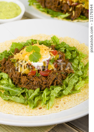 Mexican shredded beef in soft corn tortilla and toppings. Mexican shredded beef in soft corn tortilla and toppings. 11576944