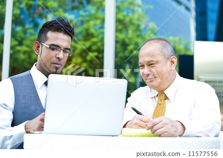 Young executive making presentation to senior executive on laptop 11577556