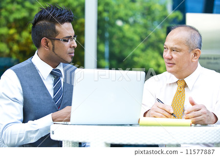 Young executive making presentation to senior executive on laptop Young executive making presentation to senior executive on laptop 11577887