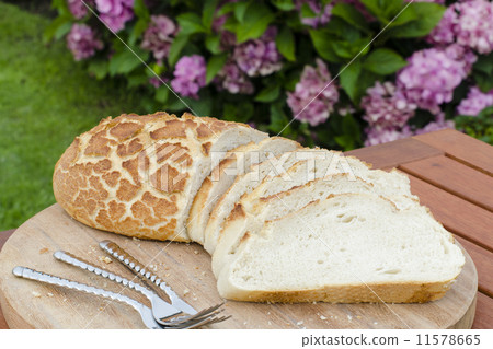 Tiger Bread - Crusty sliced white bread on a wooden board  11578665