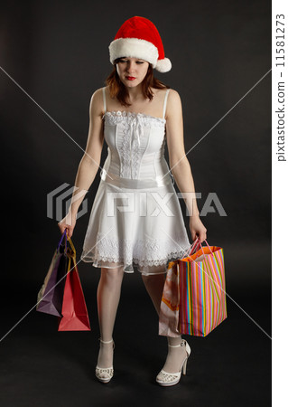 Comical tired woman in New Year's cap with purchases Comical tired woman in New Year's cap with purchases 11581273