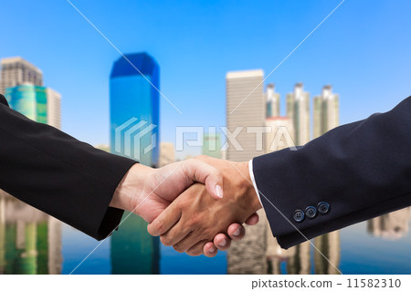 Businessman handshake with building background 11582310