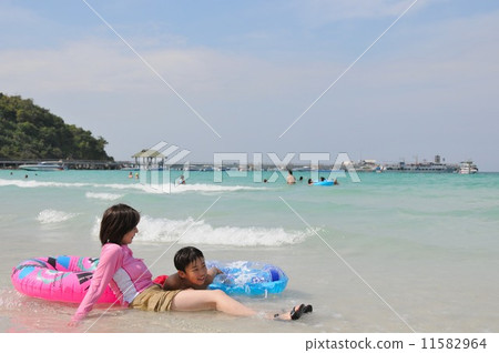 Mother and son relaxing on the beach 11582964