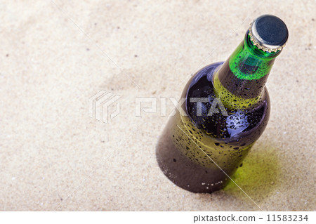 Beer bottle on a sandy beach 11583234