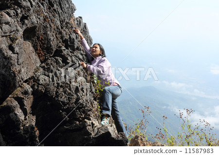 Woman climbing rock 11587983
