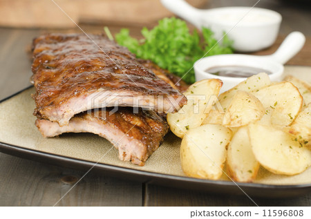 BBQ Ribs - Pork ribs & potato wedges. BBQ sauce & sour cream  11596808