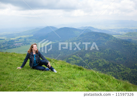 Girl sitting on the slope of volcano in Auvergne 11597326