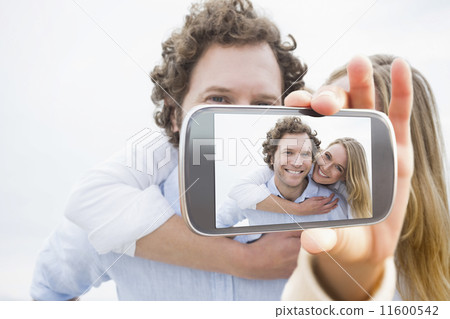 Composite image of hand holding smartphone showing 11600542