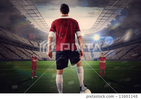 Football player in red with ball facing opposition Football player in red with ball facing opposition 11601148