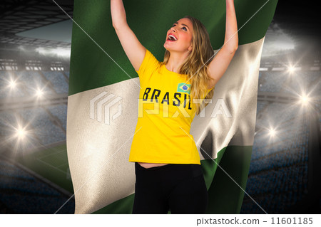 Composite image of excited football fan in brasil tshirt holding 11601185