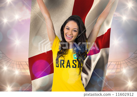 Composite image of excited football fan in brasil tshirt holding Composite image of excited football fan in brasil tshirt holding 11602912