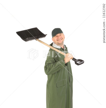 Man in green coat with snow shovel. 11612392